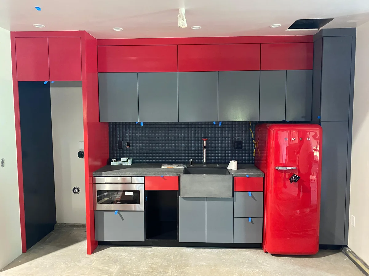 Bare wood kitchenette cabinetry finished in bold red and gray — after