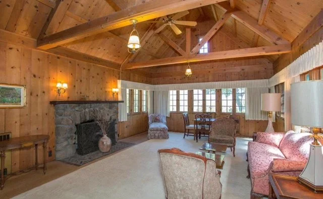 Knotty pine living room repainted to a light modern finish — before