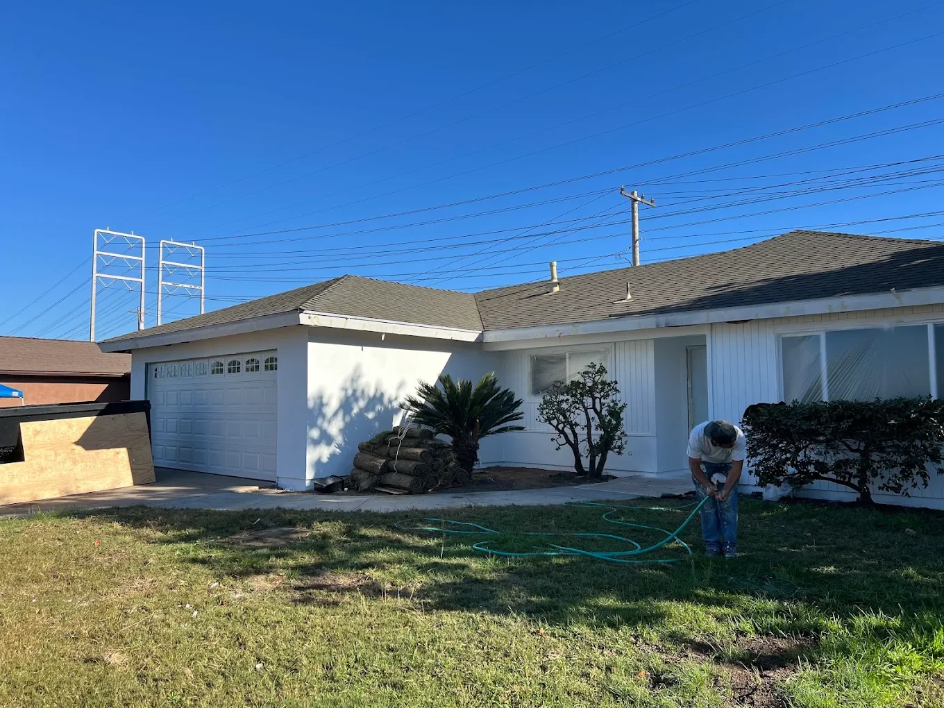 White ranch exterior being pressure washed before painting