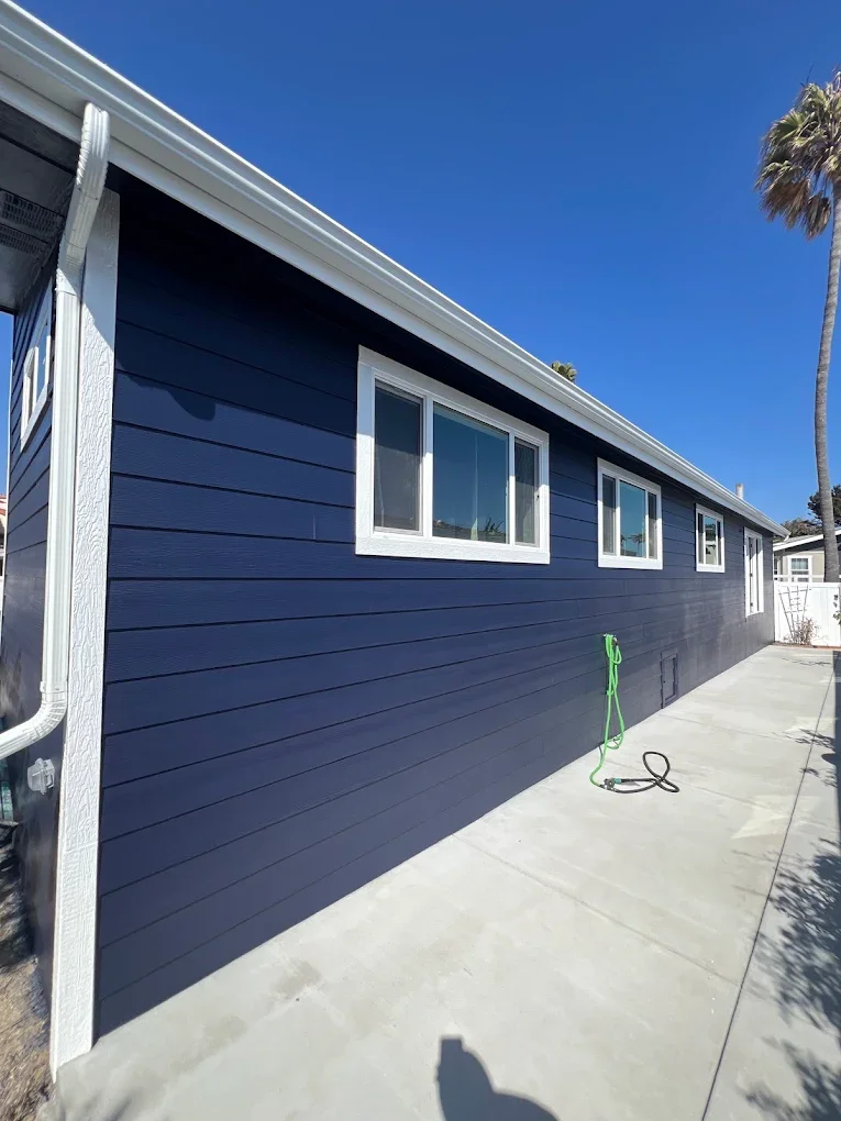 Navy blue horizontal-siding house exterior with white trim