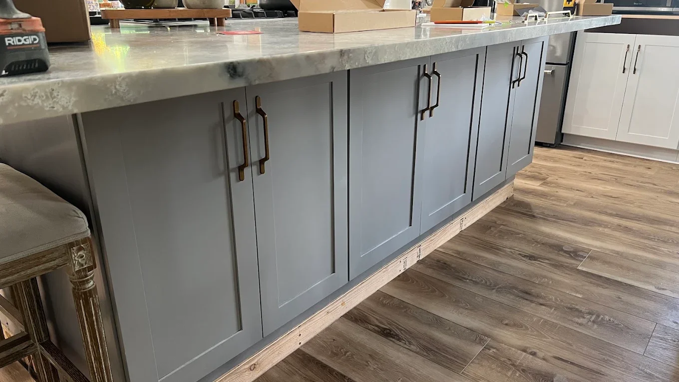 Kitchen island freshly painted blue-gray with brass hardware