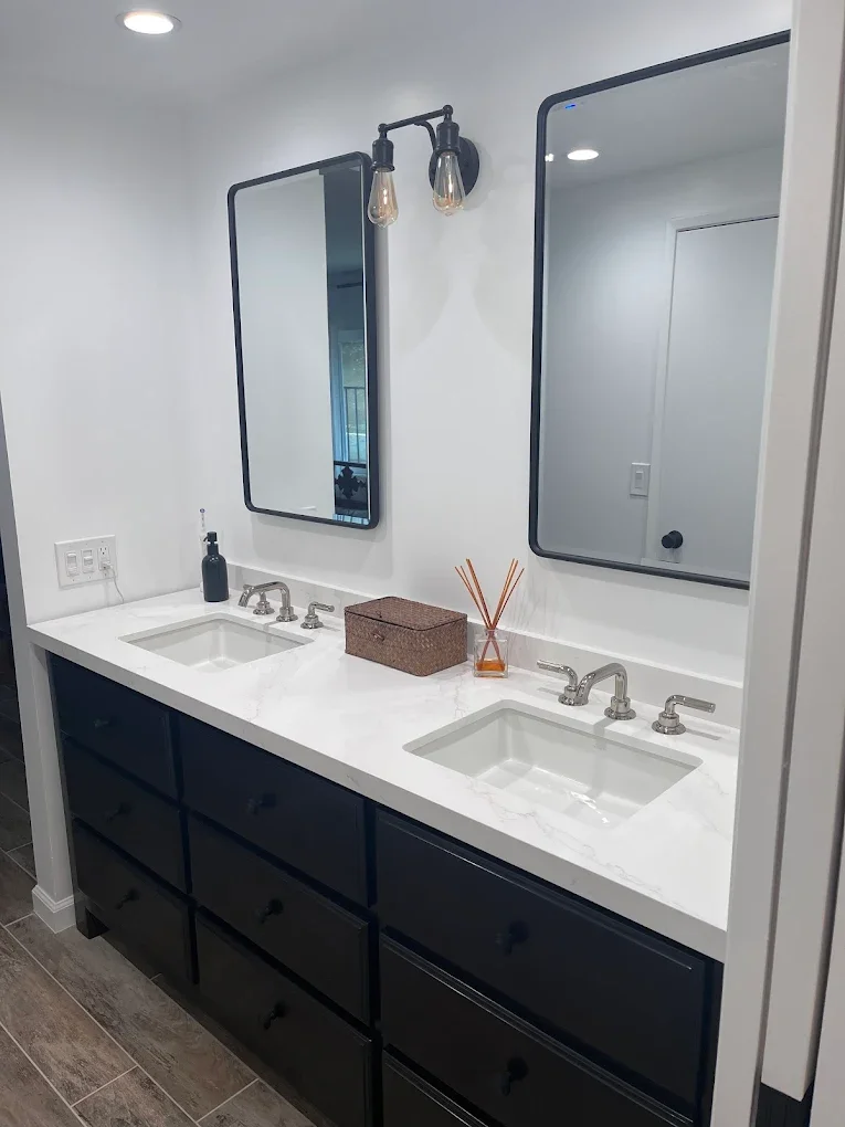 Bathroom double vanity with black cabinetry and white quartz counter