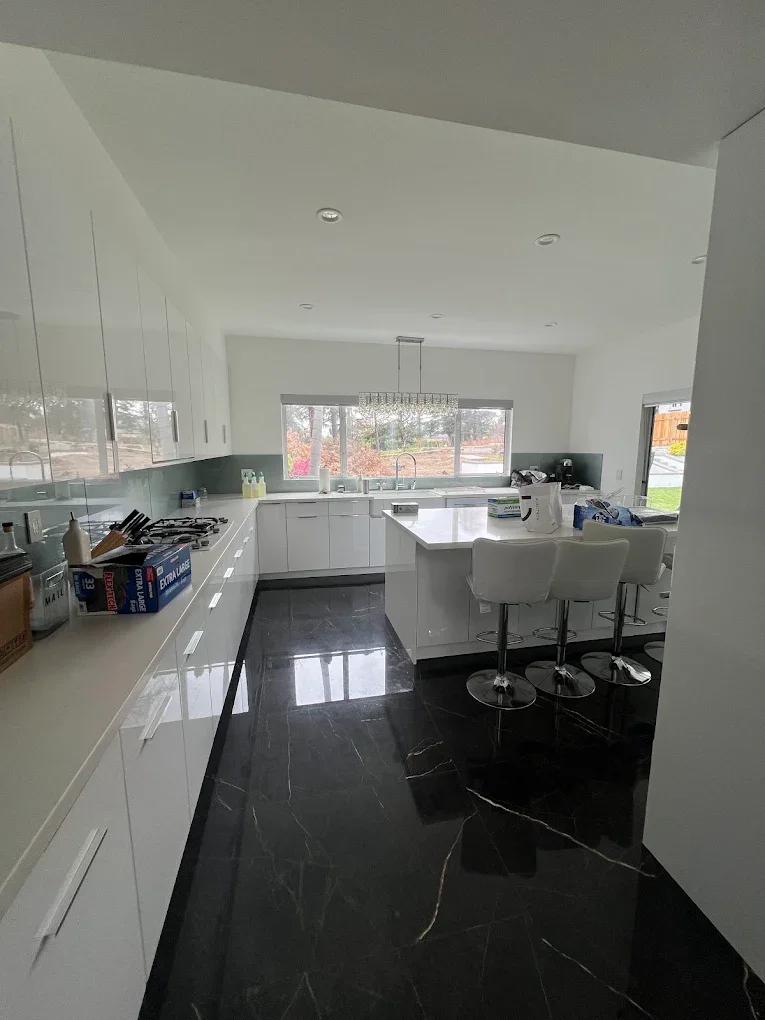 White kitchen with glossy black marble-look floor