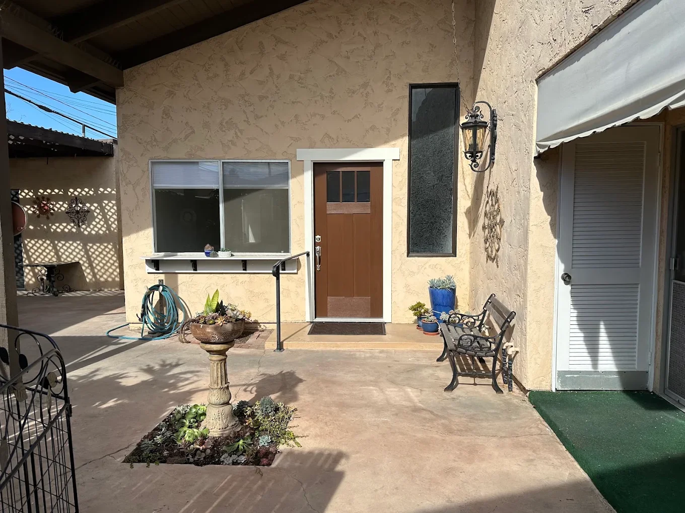 Tan stucco patio with a wood-look door and courtyard seating