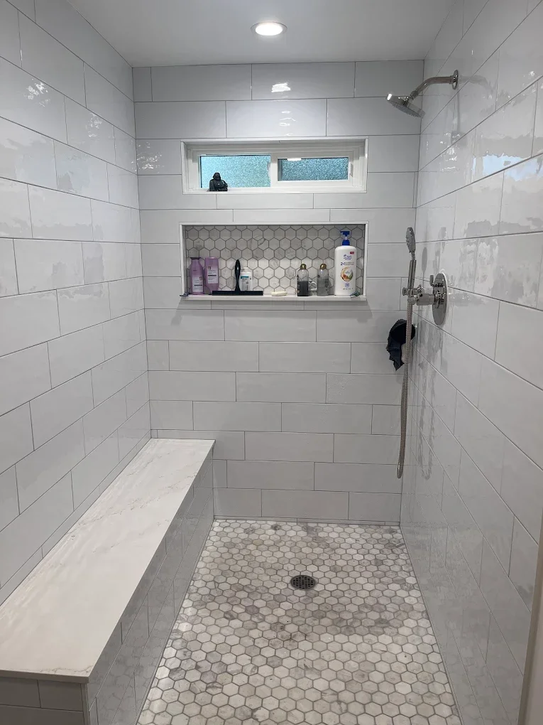 Shower stall with white subway tile and mosaic floor