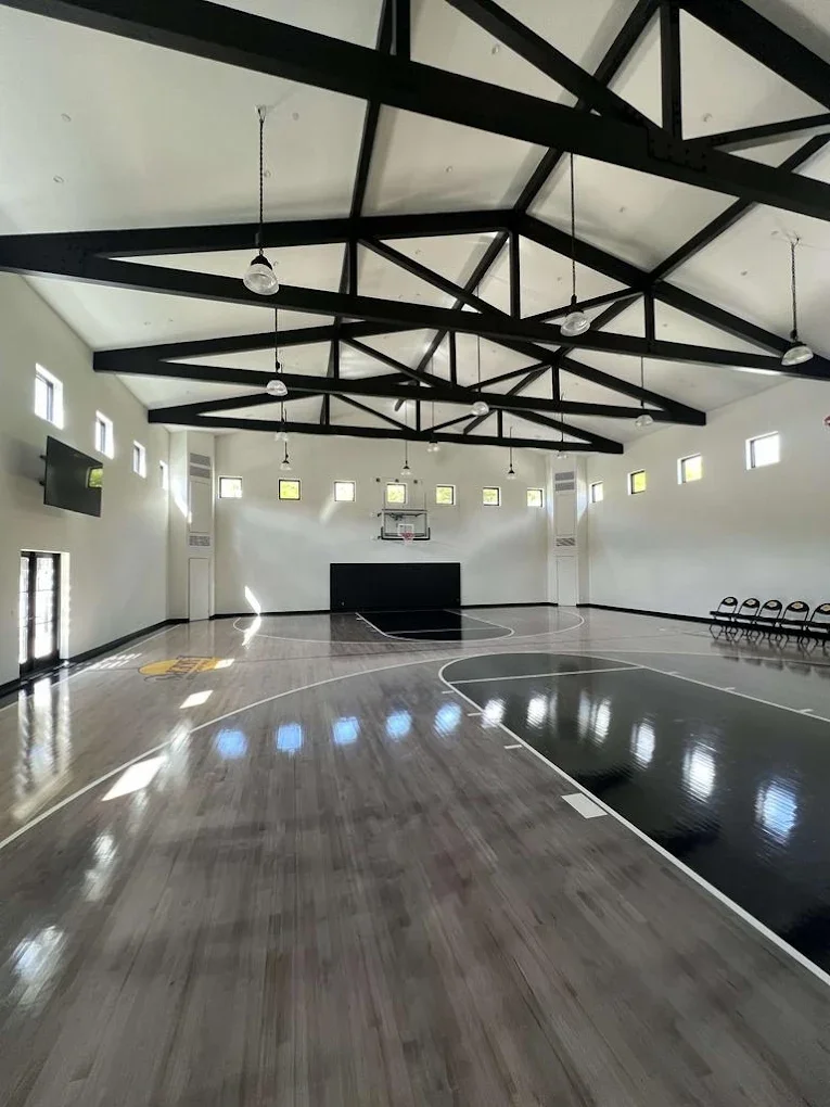 Custom home gym with black steel trusses
