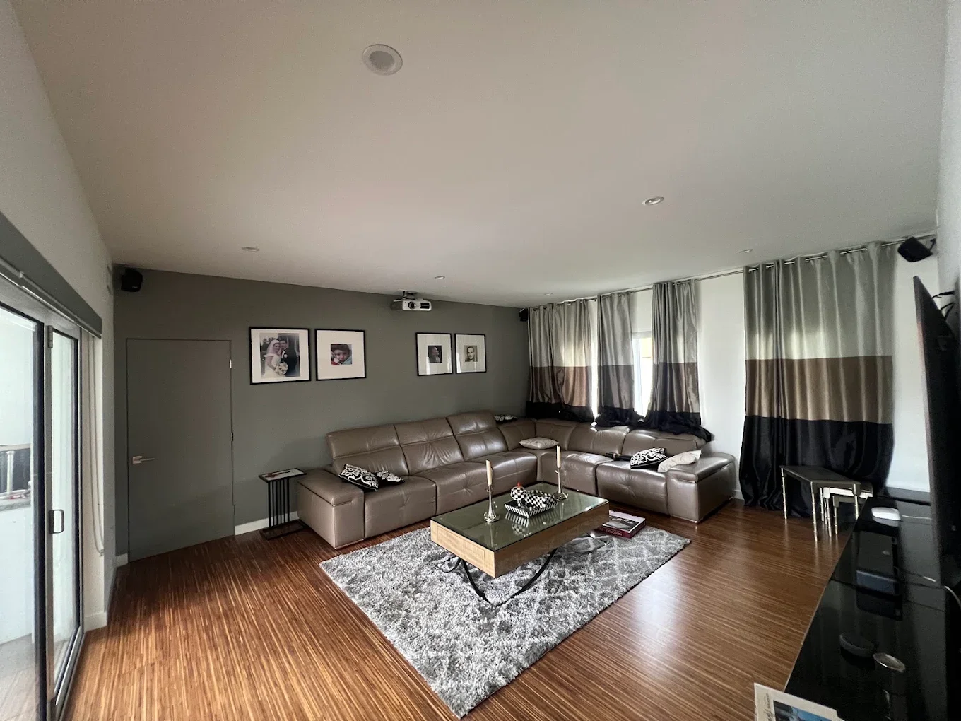 Living room with an olive-gray accent wall and leather sectional