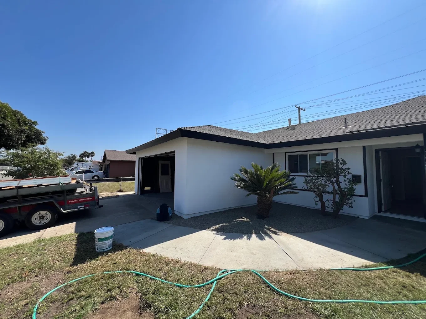 Single-story stucco ranch exterior with white body and black trim